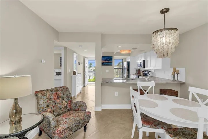Dining room with light tile patterned flooring, a chandelier, and recessed lighting