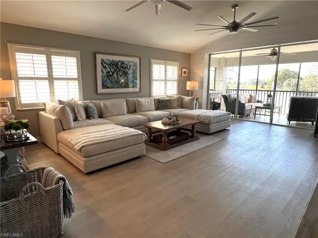 Living room with vaulted ceiling and light hardwood / wood-style floors