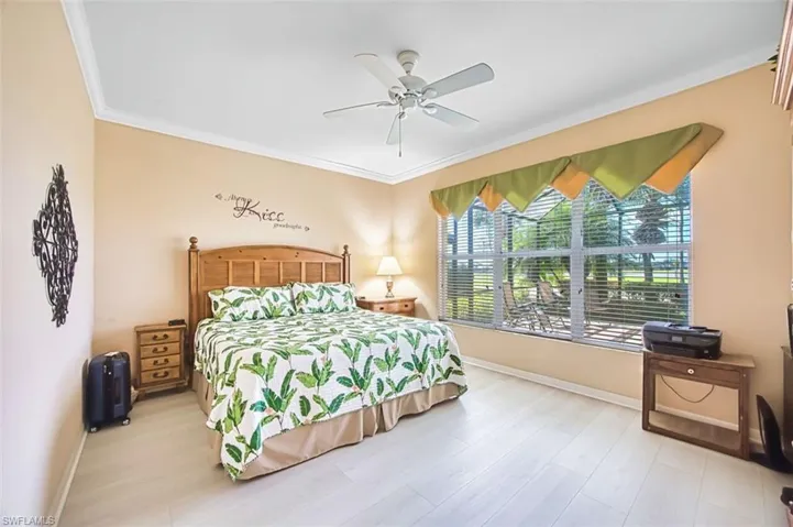 Bedroom featuring ornamental molding, ceiling fan, and wood finished floors