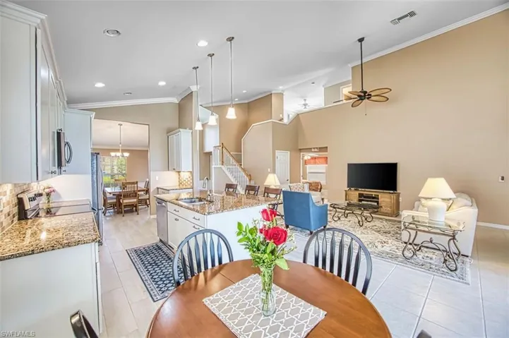 Dining area featuring crown molding, light tile patterned floors, a ceiling fan, lofted ceiling, and recessed lighting