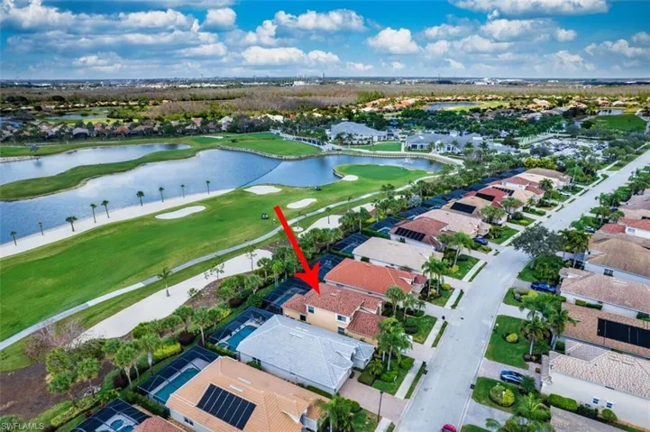 Aerial view of residential area with a golf club and a large body of water