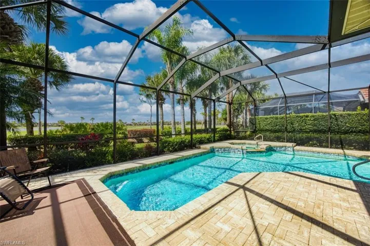 Combined pool / hot tub featuring a sunroom, a patio, and glass enclosure