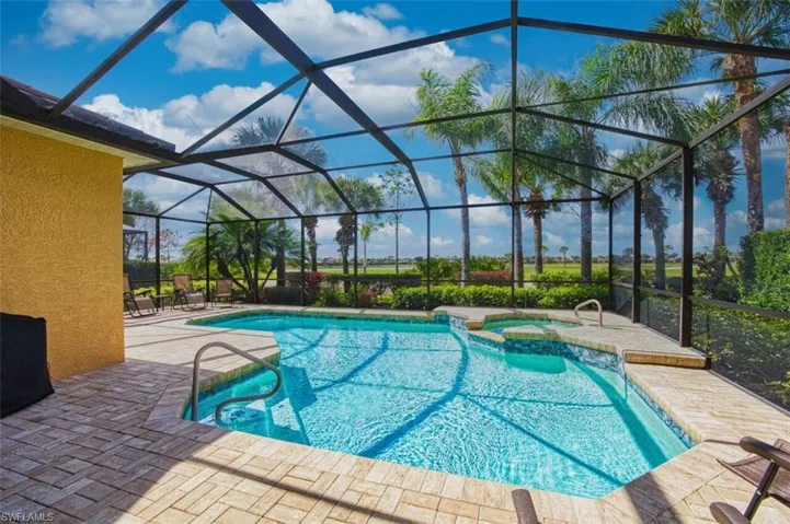 Relaxing pool / spa with a patio, a sunroom, and a lanai