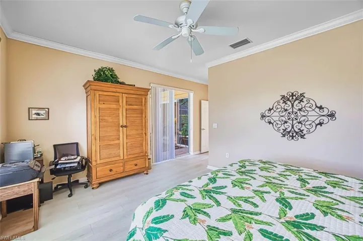 Bedroom featuring crown molding, light wood-style flooring, an office area, ceiling fan, and access to exterior