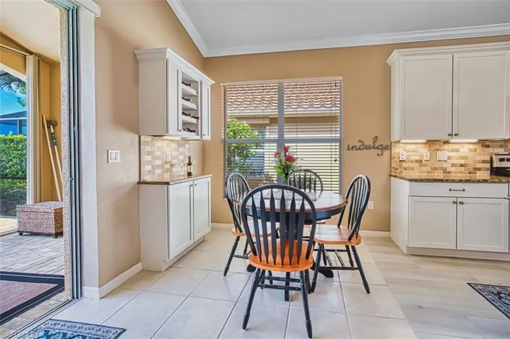 Dining room with ornamental molding and light tile patterned flooring