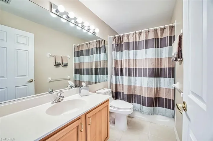 Bathroom with vanity, light tile patterned floors, and shower / tub combo