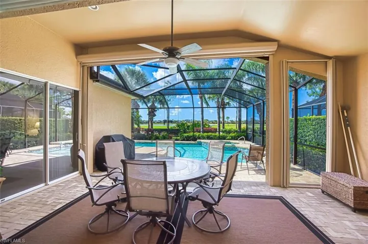 Sunroom with a patio, a swimming pool, outdoor dining area, and a ceiling fan