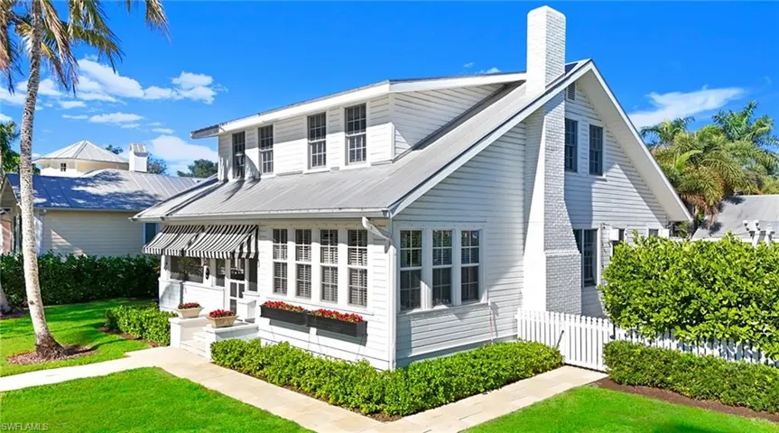 View of front facade featuring a chimney and a metal roof