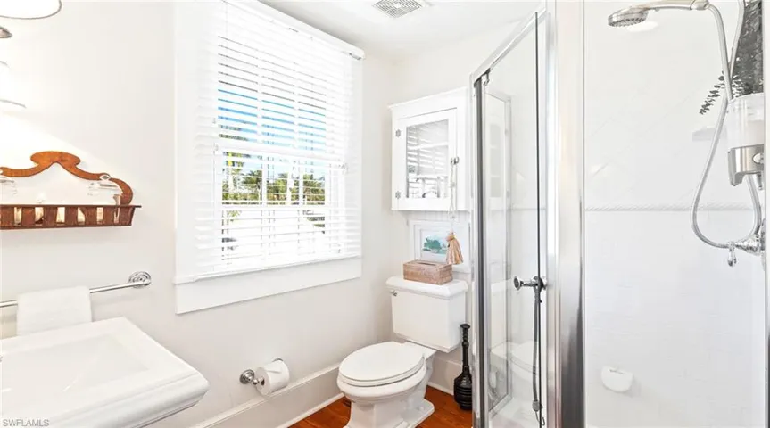 Full bathroom with a shower stall and dark wood-style flooring