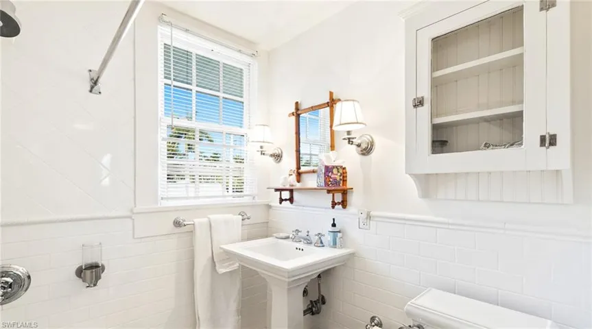 Bathroom with tile walls and a wainscoted wall