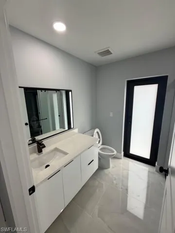 Bathroom with vanity and light marble finish flooring
