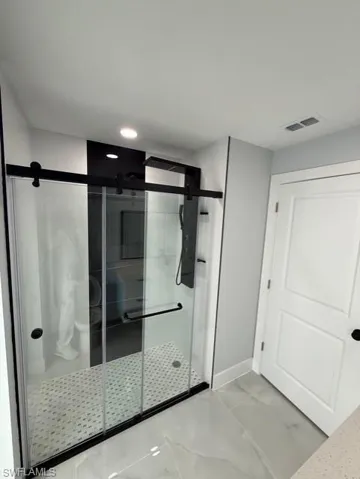 Bathroom with a stall shower and baseboards