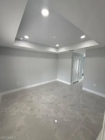 Finished below grade area with recessed lighting and light marble finish floors