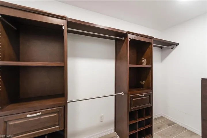 Walk in closet with light wood finished floors