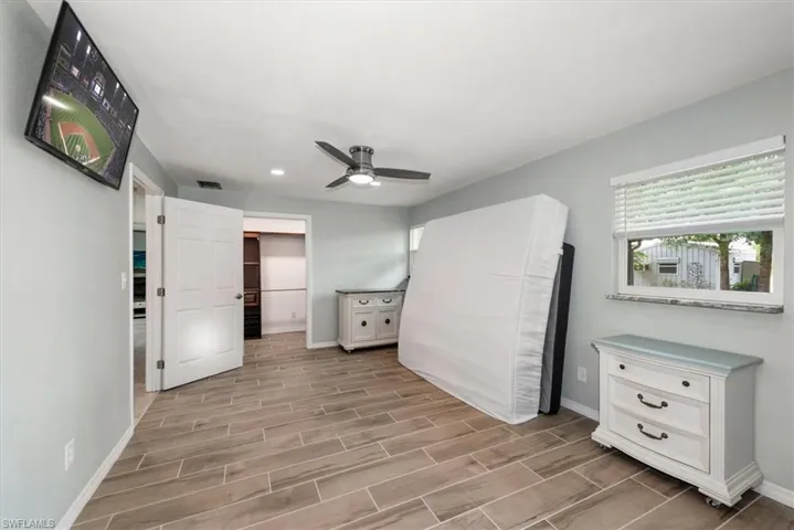 Unfurnished bedroom featuring baseboards, wood tiled floors, recessed lighting, and a ceiling fan