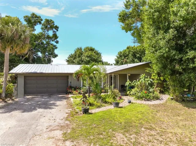 Ranch-style home lush landscaping, 2 car garage, and metal roof