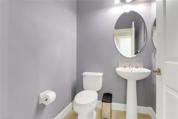 Half bath featuring tile patterned flooring, toilet, and baseboards
