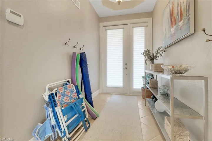 Doorway to outside with plenty of natural light, baseboards, light tile patterned floors, and visible vents
