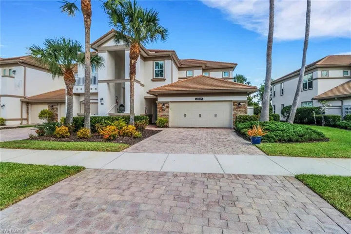 Mediterranean / spanish home featuring an attached garage, stone siding, stucco siding, a tiled roof, and decorative driveway