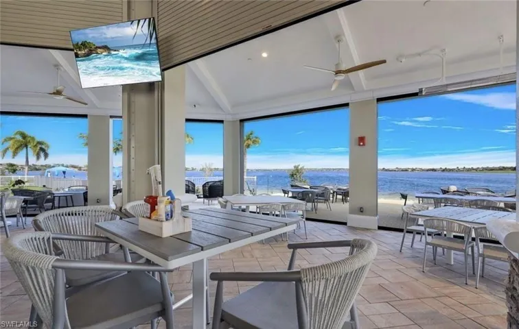 View of patio with outdoor dining area, a water view, and a ceiling fan