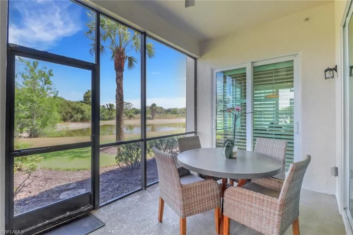 Sunroom with a wealth of natural light, a water view, and outdoor dining space