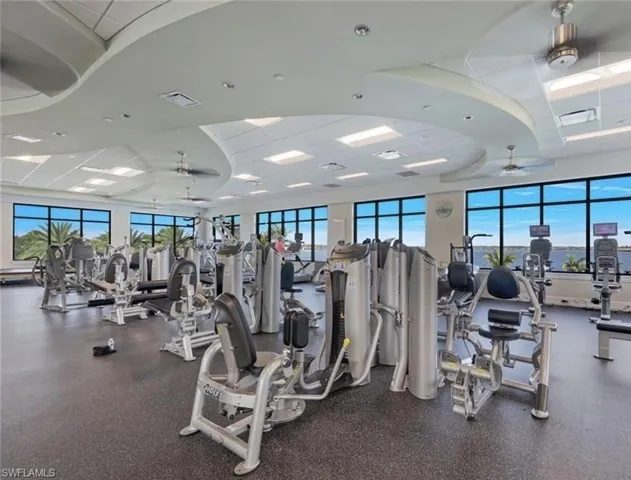 Exercise room featuring a ceiling fan, a healthy amount of sunlight, and visible vents