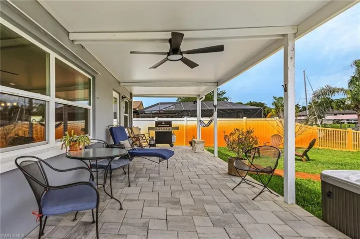 View of patio / terrace with fence, a lanai, a grill, and a ceiling fan