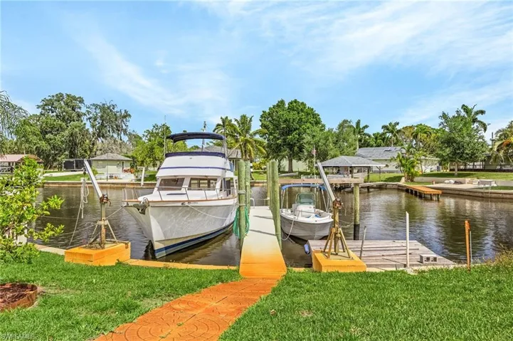 Dock area with a water view and a lawn