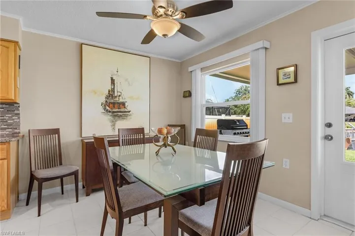 Dining space with ornamental molding, ceiling fan, and baseboards