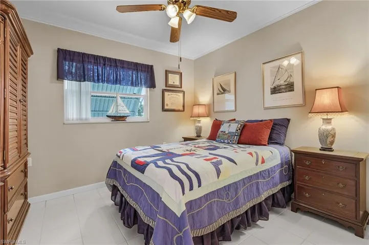 Bedroom featuring crown molding, baseboards, and a ceiling fan