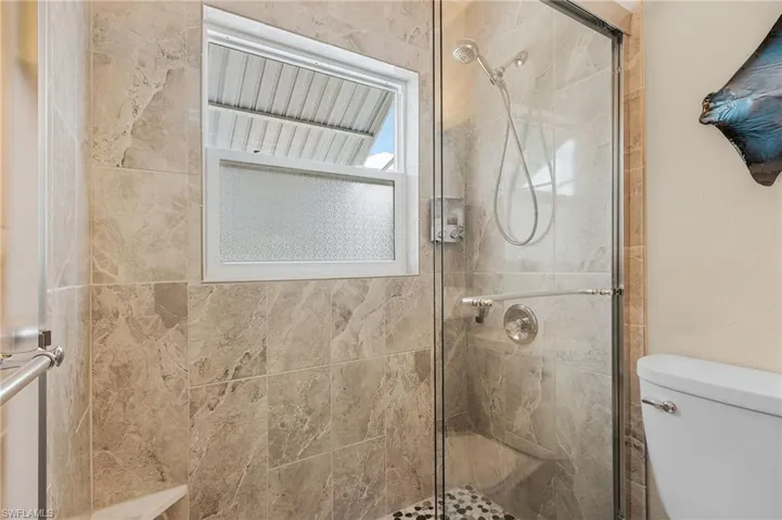 Full bath with toilet and a stall shower
