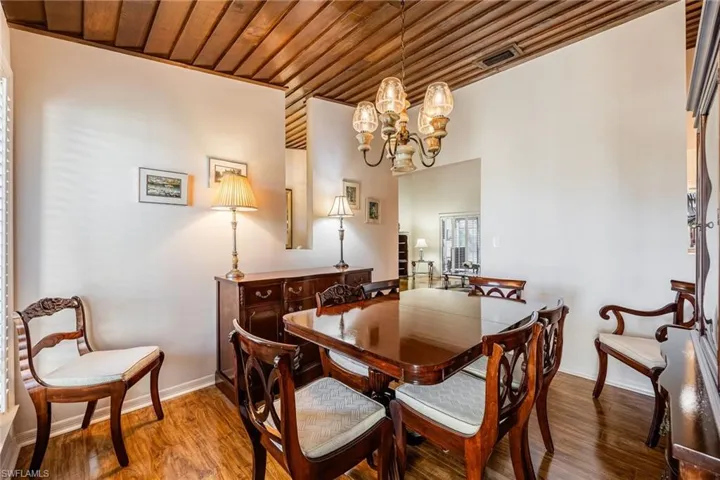 Formal Dining room featuring wood-type flooring, an inviting chandelier, and wooden ceiling