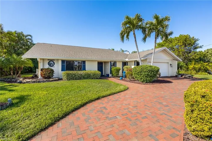 Ranch-style house featuring a garage and circular driveway