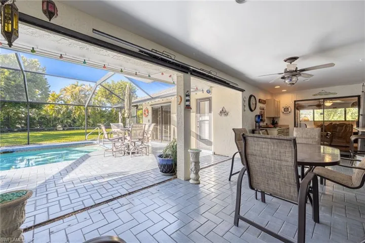 View of pool from covered area with outdoor kitchen