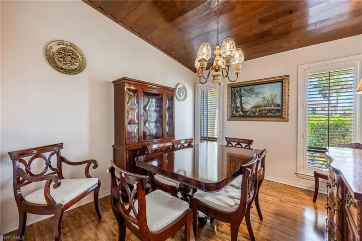 Formal Dining room featuring a chandelier, hardwood / wood-style flooring, vaulted ceiling, and wood ceiling