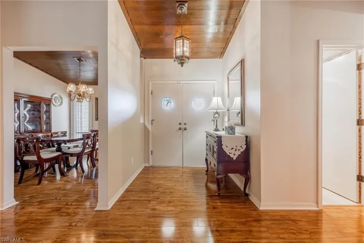 Foyer entrance featuring wood ceiling, a chandelier, and wood flooring