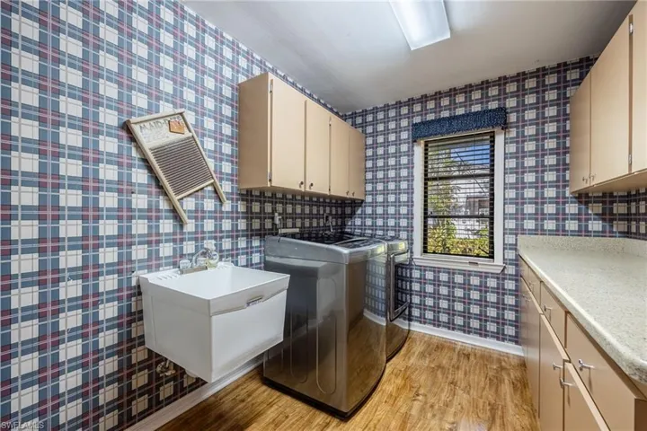 Washroom featuring cabinets, laundry tub and folding area