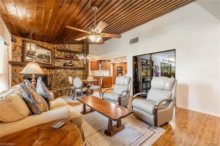 Living room featuring wooden ceiling, ceiling fan, light wood-type flooring, and lofted ceiling