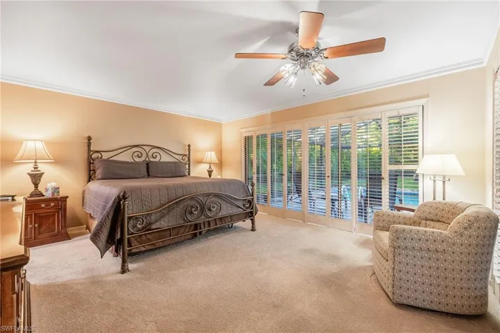 Master Bedroom with ceiling fan, access to exterior, crown molding, and light carpet