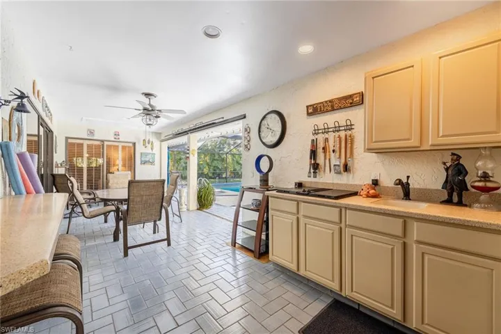 Outdoor Kitchen featuring cabinetry, ceiling fan, grill and sink