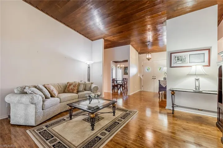 Living room with a chandelier, hardwood / wood-style floors, and wooden ceiling
