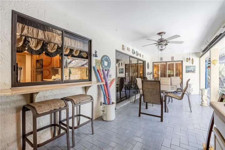 Dining space with ceiling fan with pass-through from kitchen