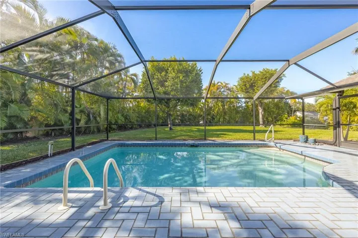 View of pool with a lawn, enclosure, and a patio area