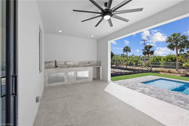 View of patio / terrace with area for grilling, a ceiling fan, and fence