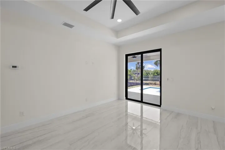 Spare room featuring visible vents, a ceiling fan, a tray ceiling, recessed lighting, and baseboards