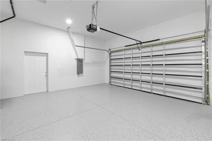 Garage featuring electric panel and a garage door opener
