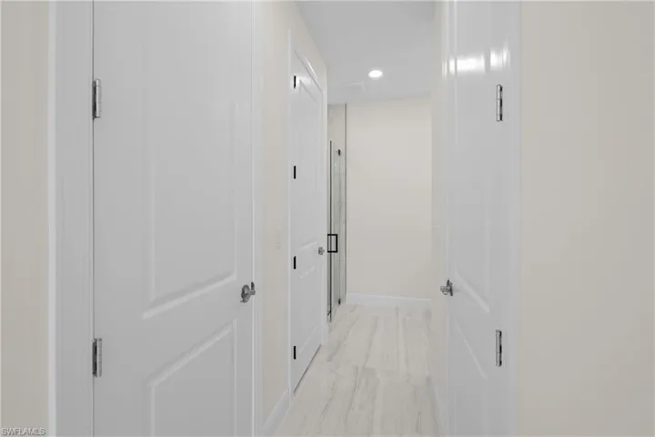 Hall featuring recessed lighting, marble finish floor, and baseboards