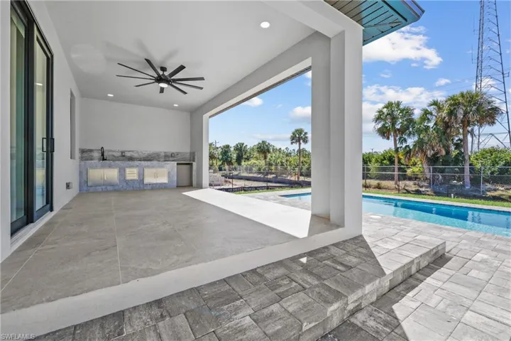 View of patio / terrace featuring an outdoor pool, a ceiling fan, and fence