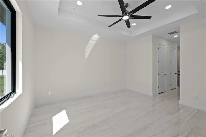 Unfurnished room with visible vents, ceiling fan, baseboards, recessed lighting, and a raised ceiling