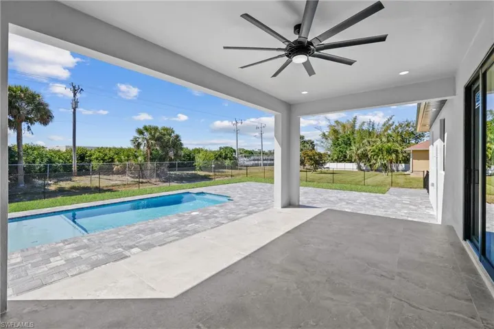 View of swimming pool featuring a ceiling fan, a fenced in pool, a fenced backyard, a patio area, and a lawn